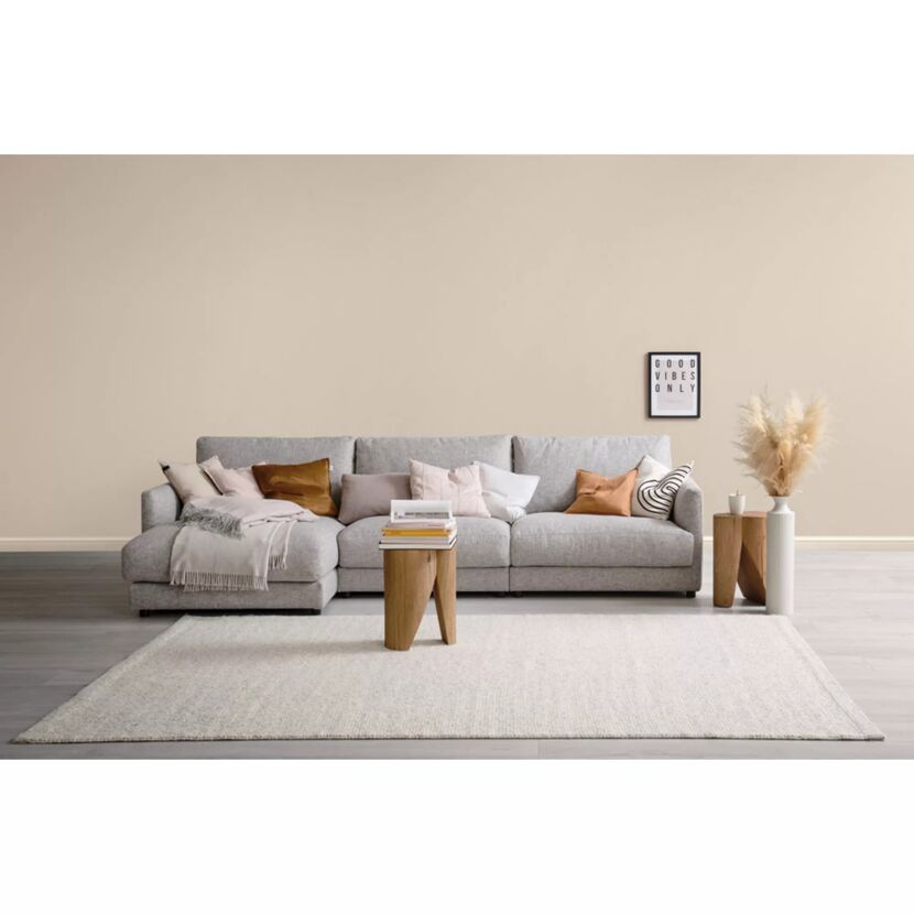 Graues Ecksofa mit Dekokissen und Behocker