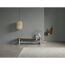 Holzbank mit Deko und Bambuslampe an grauer Wand.