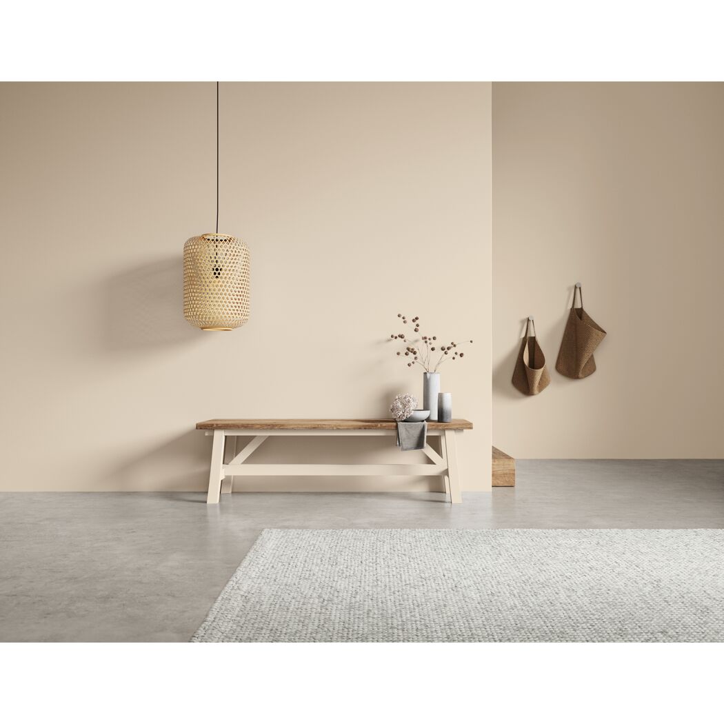 Wohnzimmer mit Bank, Lampe und Taschen an der Wand