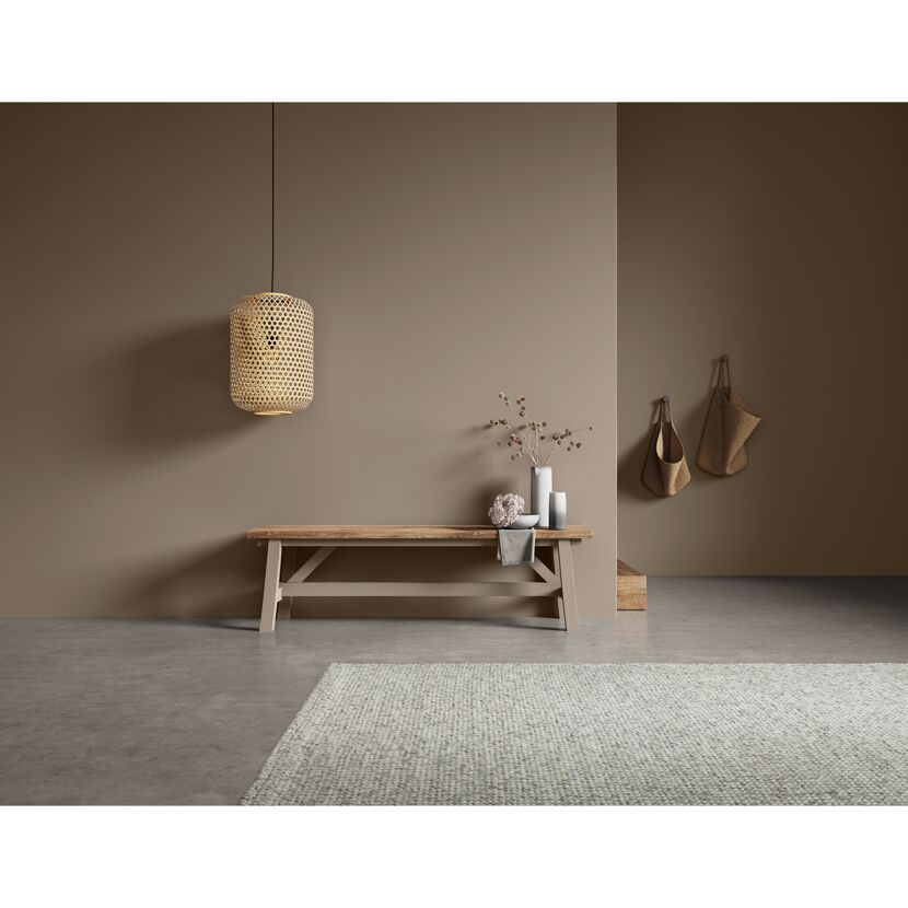 Holzbank mit Korblampen und Teppich