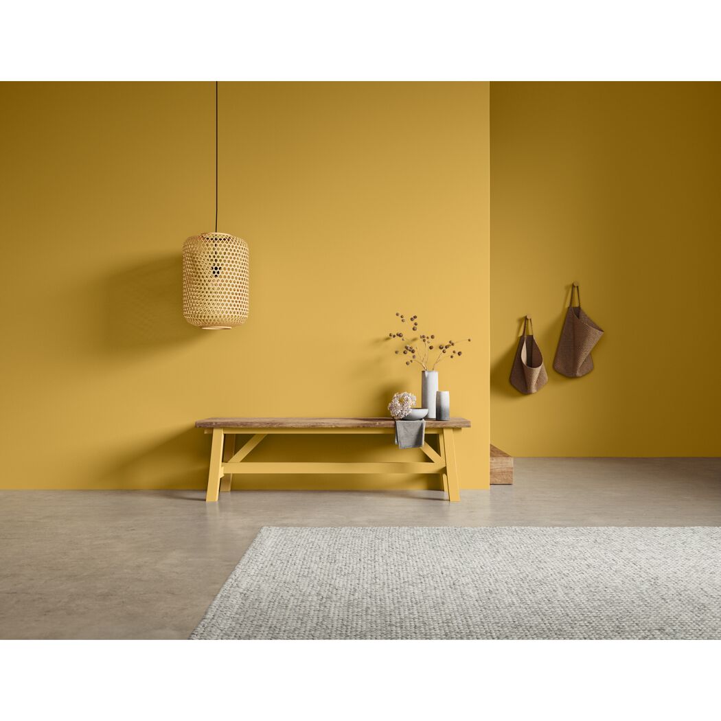 Gelber Raum mit Holzbank und Teppich