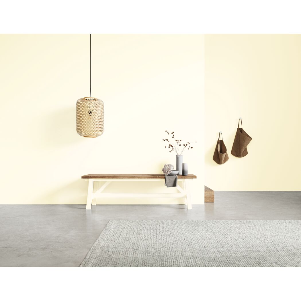 Eingangsbereich in Cremeweiß mit Korblampen, Holzbank und Taschen.
