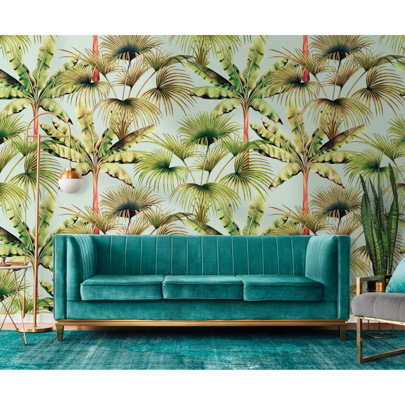 Grünes Sofa vor einer Tapete mit Palmenmuster