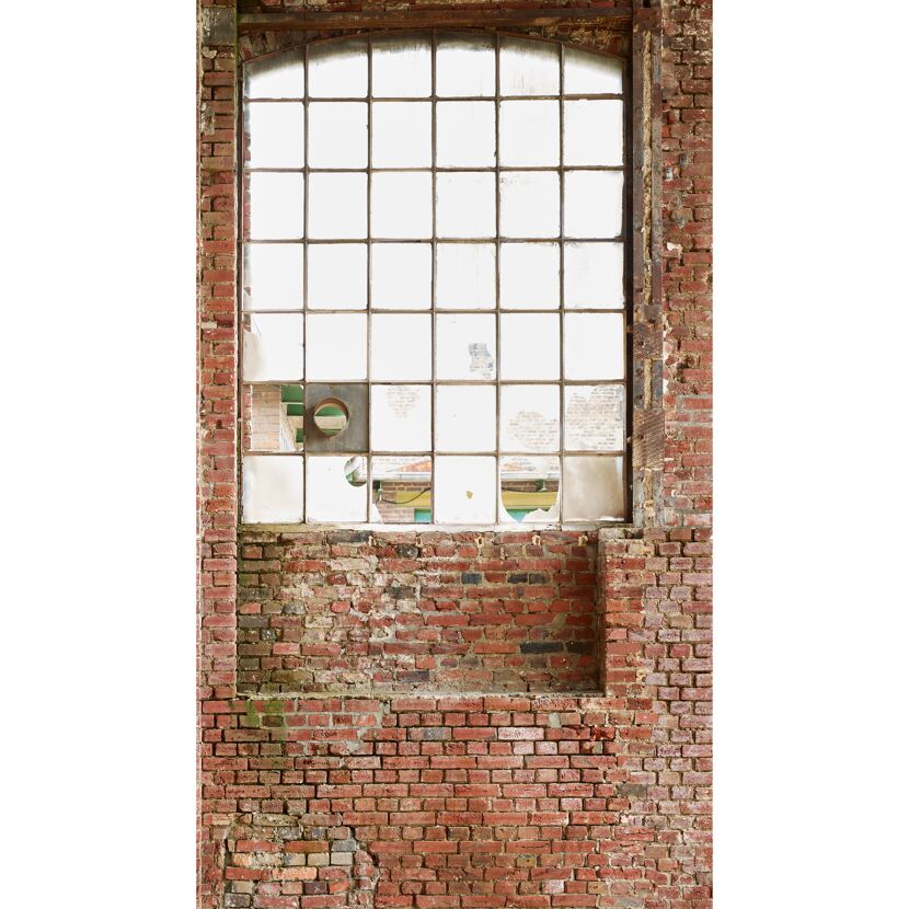 Altes Fenster mit kaputten Scheiben in Backsteinmauer