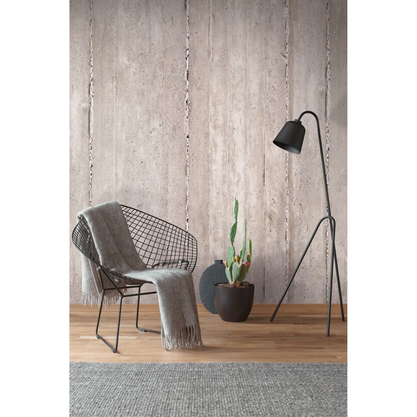 Stuhl und Stehlampe vor Betonwand