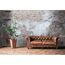 Ledersofa und Pflanze vor Backsteinwand