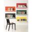 Bunte Bücherregale mit einem schwarzen Stuhl