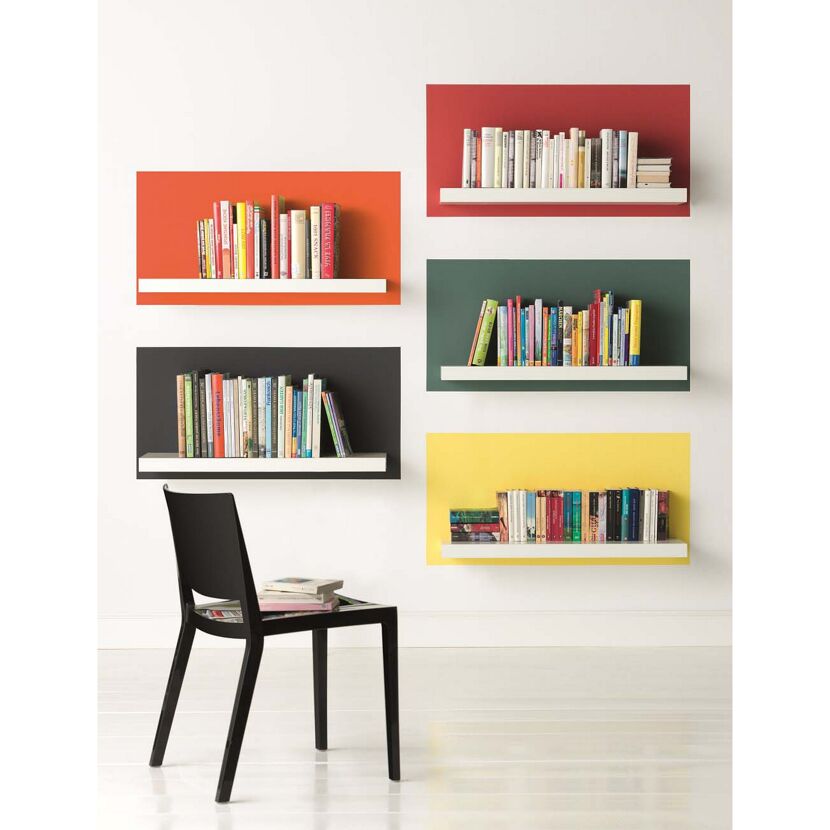Bunte Bücherregale mit einem schwarzen Stuhl