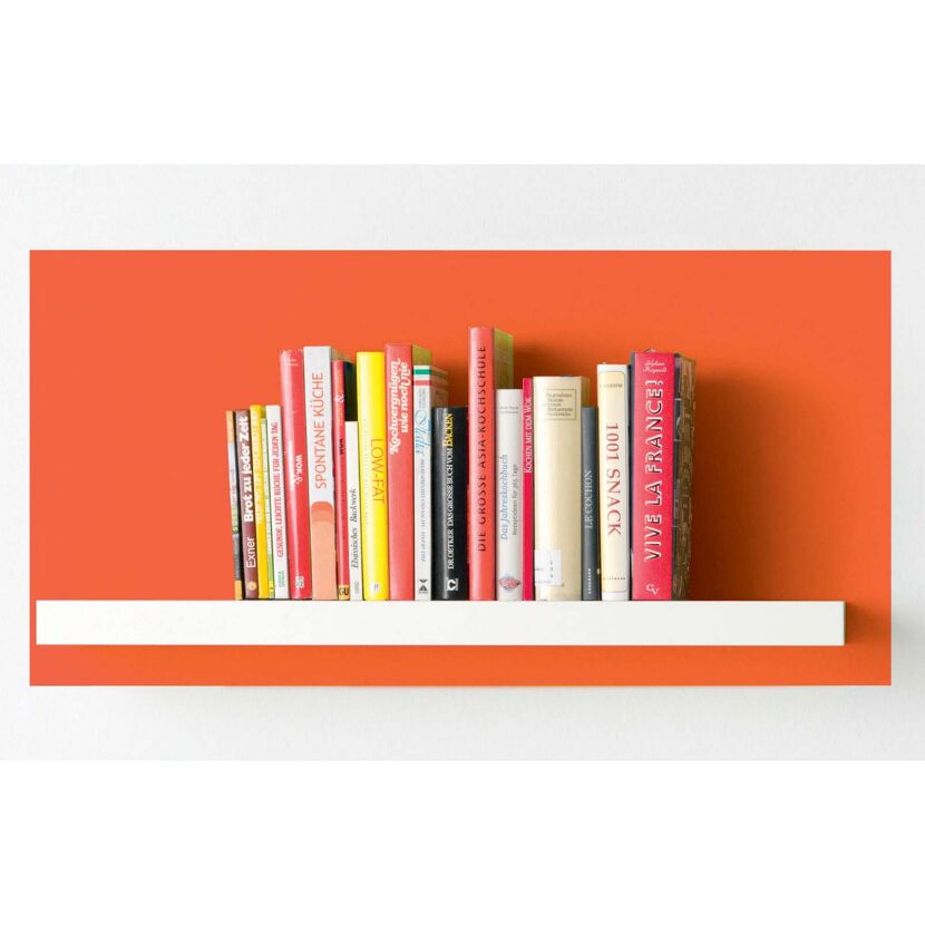 Kochbücher auf einem weißen Regal vor orangefarbener Wand