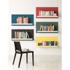 Bunte Bücherregale mit Stuhl im Vordergrund