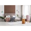 Schlafzimmer mit Bett, Sessel, Lampe, Teppich und Pflanzen