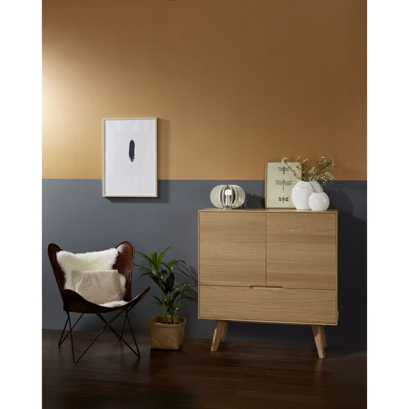 Wohnzimmer mit Holzkommode, Ledersessel und Deko