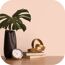 Monstera-Blatt in einer Vase, daneben eine Uhr und Bücher