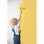 Person streicht Wand mit Farbrolle gelb