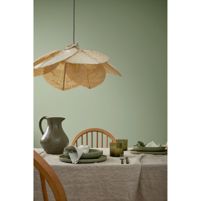 Gedeckter Esstisch mit Weidenlampe und Wandfarbe in Eukalyptusgrün