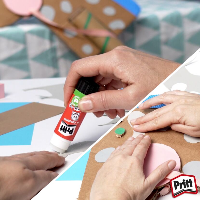 Person klebt Papierformen mit Pritt Stift auf Karton.