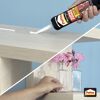 Person klebt mit Pattex Montagekleber ein Regal an die Wand.