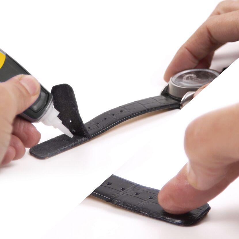 Person klebt ein schwarzes Uhrenarmband mit Kleber.
