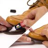 Eine Person klebt einen Schuh mit Pattex Sekundenkleber.