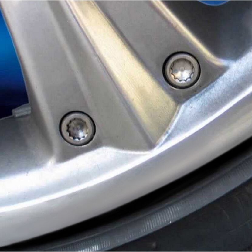 Nahaufnahme einer silbernen Autofelge mit zwei Schrauben.