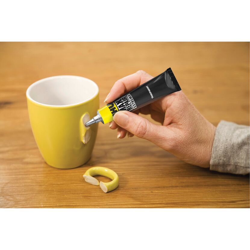 Person klebt Henkel einer Tasse mit UHU Max Repair.