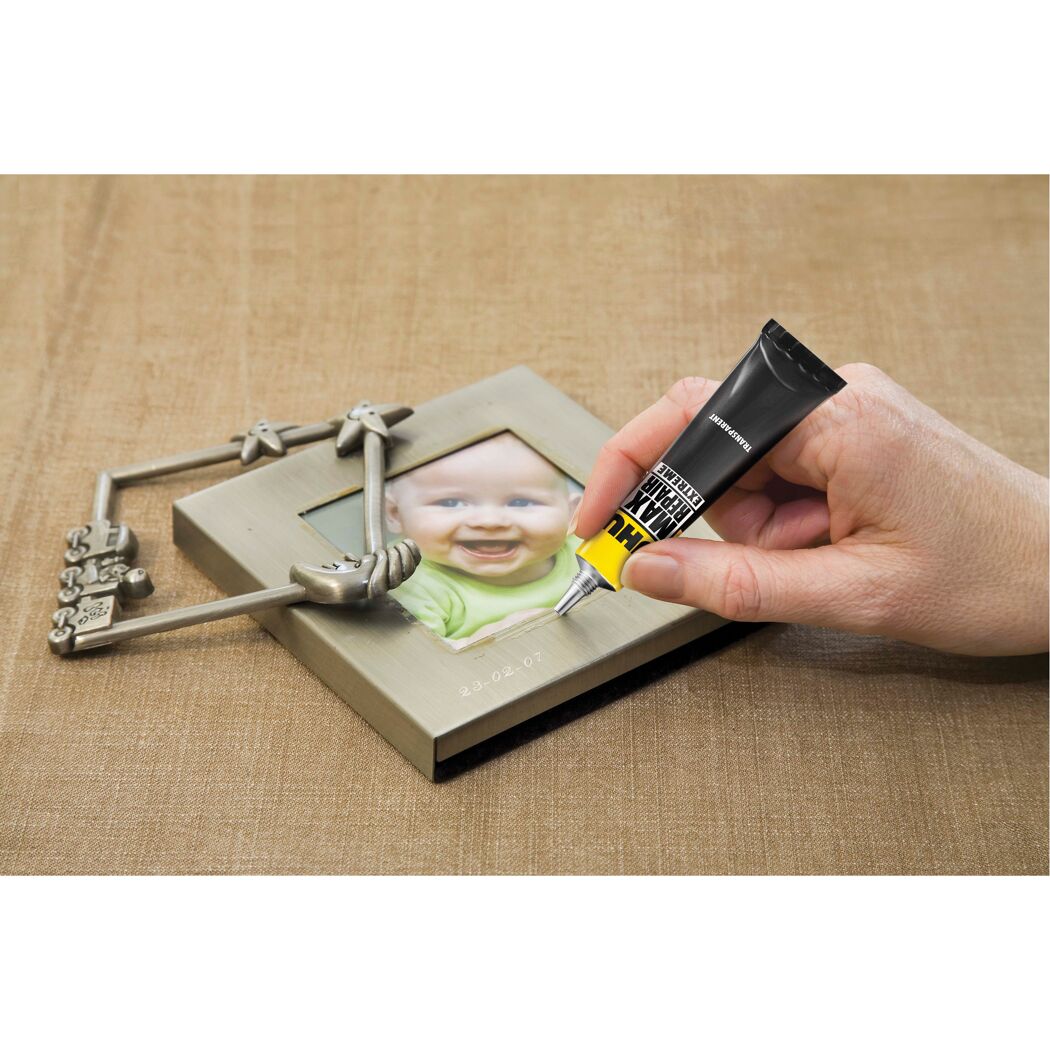 Person klebt einen Fotorahmen mit UHU Max Repair Extreme.