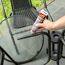 Person klebt einen schwarzen Gartenstuhl mit UHU Poly Max.