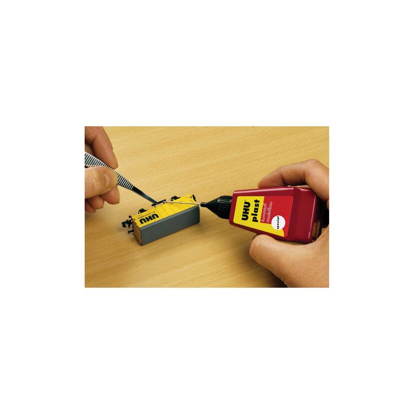 Person klebt mit UHU plast Spezialkleber ein Modell zusammen.