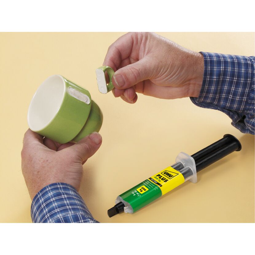 Person klebt Henkel an Tasse mit UHU plus endfest.