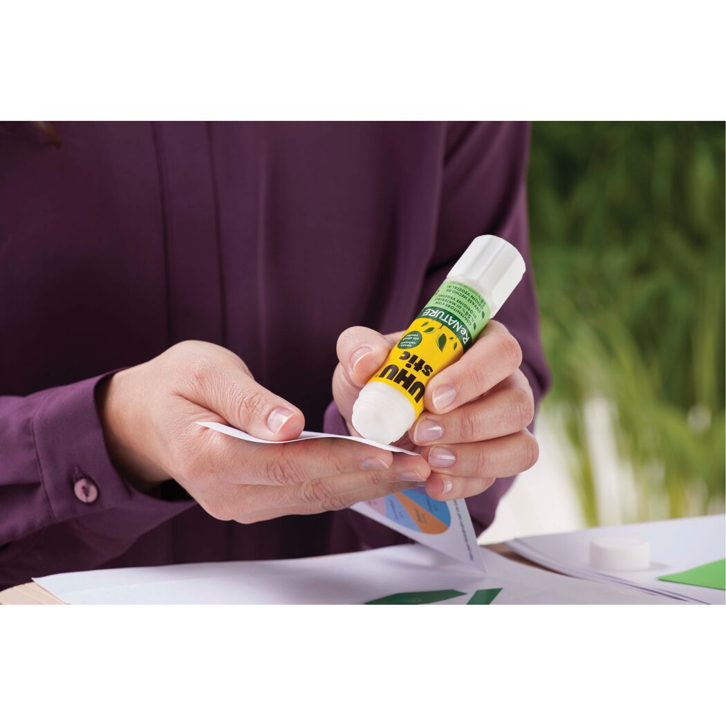 Person klebt Papier mit UHU stic ReNATURE Klebestift