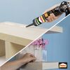 Person klebt ein Regal mit Pattex Montagekleber an die Wand.