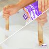 Person rührt Kleister mit einem Holzrührstab an