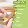Person klebt Klebestreifen auf Holz