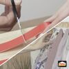 Person schneidet Pattex Klebeband mit Schere zu.