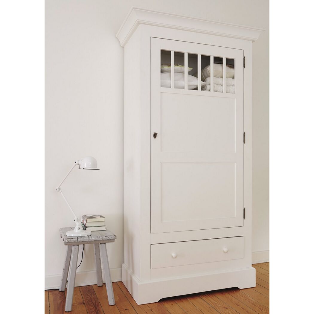 Weißer Kleiderschrank mit einer Schublade und einem Gitterfenster