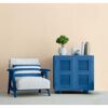 Blauer Schrank und blauer Sessel mit gestreiftem Kissen
