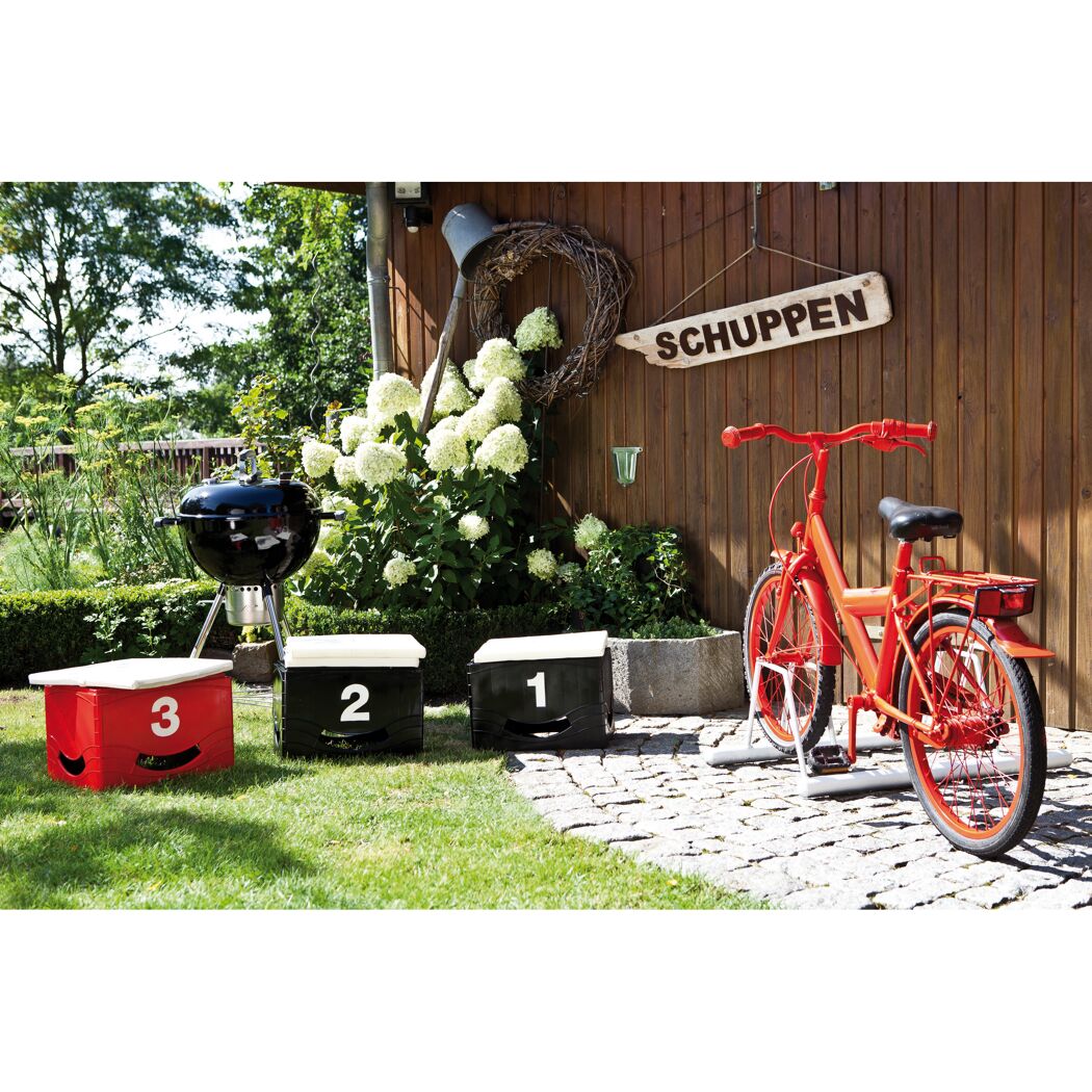 Rotes Fahrrad, Grill und Siegertreppchen im Garten