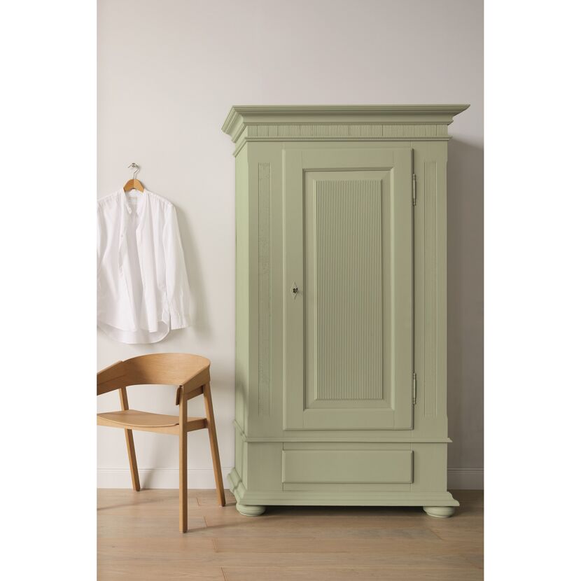 Grüner Kleiderschrank mit einem Hemd und einem Stuhl
