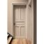 Geschlossene beige Tür in einem Flur mit Holzboden und Treppe.
