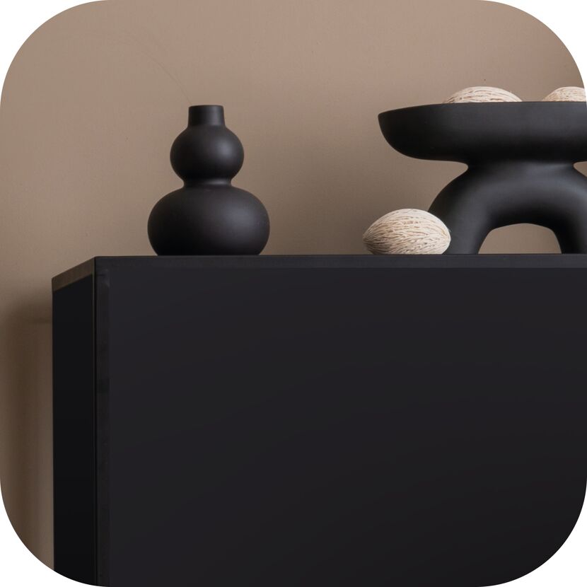 Schwarzes Sideboard mit Deko