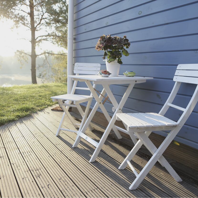 Tisch und Stühle auf einer Holzterrasse