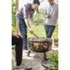 Personen grillen auf einer Feuerschale mit Grillfunktion
