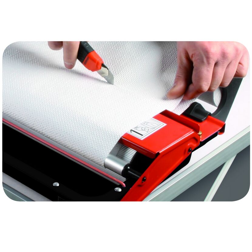 Person schneidet Tapete mit Cuttermesser zu.