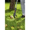 Person hebt mit einem Abfallgreifer einen Apfel auf.