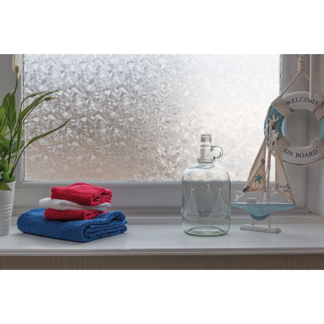 Handtücher, Glasflasche und Deko auf Fensterbank