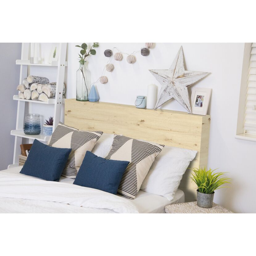 Bett mit hellem Holzkopfteil