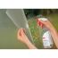 Person bringt Fensterfolie mit Sprühflasche an