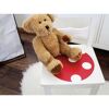 Teddybär auf einem Stuhl mit roter Klebefolie