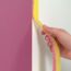 Person entfernt Malerband von einer Wand