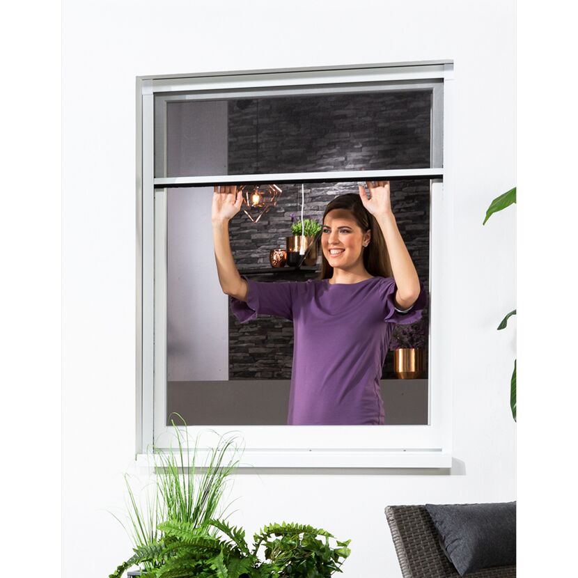Person bringt ein Insektenschutz-Rollo am Fenster an